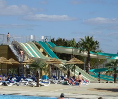 Piscine avec toboggans et transats au camping Escape MobilHome aux Dunes de Contis