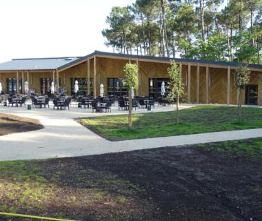 Terrasse extérieure avec tables et chaises dans la pinède de l'Escape MobilHome aux Dunes de Contis