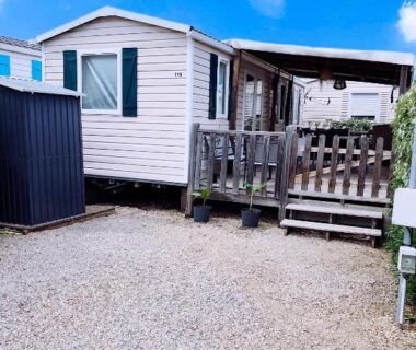 Devant le mobil-home avec terrasse sur sol gravillonné à l'Europcamping Mobil-home Climatisé
