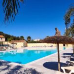 Piscine extérieure et transats au camping Europcamping Mobil-home Climatisé