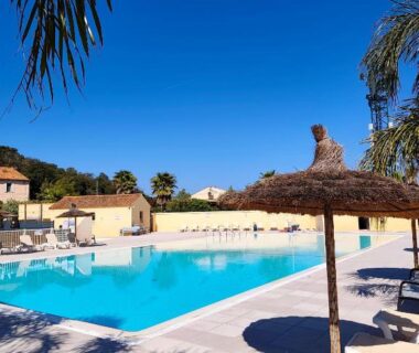 Piscine extérieure et transats au camping Europcamping Mobil-home Climatisé