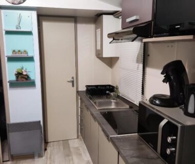 Cuisine équipée avec plan de travail cafetière et TV dans le mobil-home Europcamping Mobil-home Climatisé