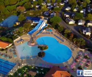 Piscine centrale avec toboggans et bassins au camping Évasion Lodge