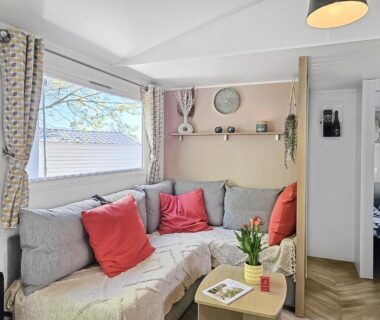 Coin salon lumineux avec canapé et coussins dans le mobil-home Evasion Normande