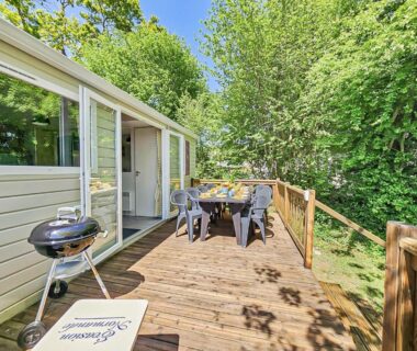 Terrasse en bois avec table et barbecue au camping Evasion Normande
