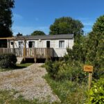 Allée gravillonnée et mobil-home avec terrasse au camping Évasion famille Dune Blanche