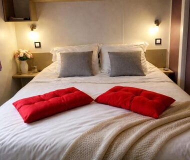 Chambre avec lit double et coussins rouges dans l'Evasion premium tout confort 4 étoiles clim ch parentale 2 SDB 2WC