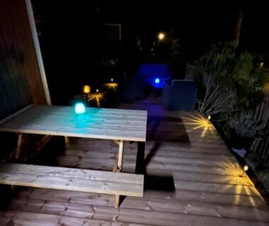 Terrasse en bois avec table et lumières de l'Evasion premium tout confort 4 étoiles clim ch parentale 2 SDB 2WC