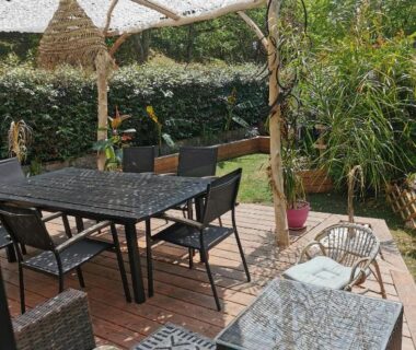 Terrasse ombragée avec salon de jardin et plantes du Domaine Évasion tout confort pour 4