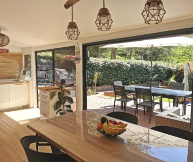 Coin repas intérieur et terrasse avec transats dans l'hébergement Évasion tout confort pour 4