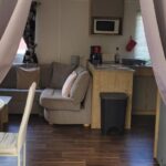 Intérieur du logement avec salon kitchenette et table à manger dans l'hébergement Évolution