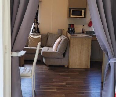 Terrasse et séjour avec canapé et kitchenette du mobil-home Évolution