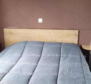 Chambre avec lit double tête de lit et rangement dans le camping Évolution