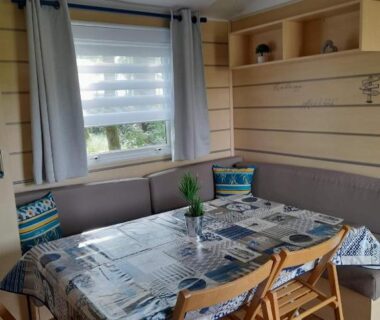 Coin repas intérieur avec table et banquette dans le F4 PREMIUM 6 pers PUY DU FOU 910CF