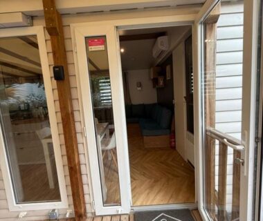 Terrasse en bois avec porte-fenêtre ouverte du FMLODGE mobil Inès au sable du mdi