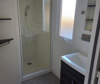 Salle d'eau avec cabine de douche et lavabo dans le FMLODGE mobil Inès au sable du mdi