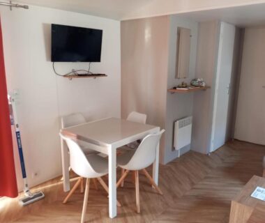 Salle à manger avec table, chaises et télévision dans le FMLODGE mobil Inès au sable du mdi