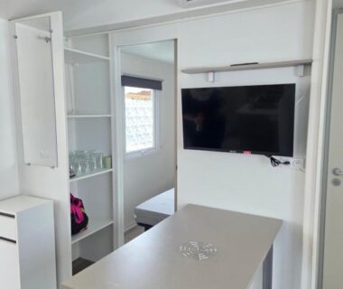 Intérieur avec table télévision climatisation et rangements du mobil home FMLODGE Le coin paradis