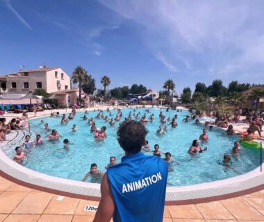 Piscine du camping avec animateur en tenue animation et baigneurs au FMLODGE mobil home Le coin paradis