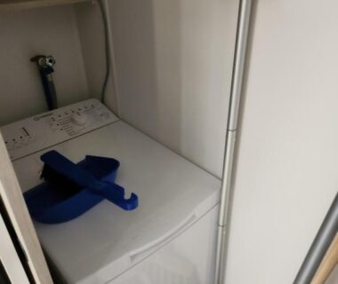 Placard buanderie avec lave-linge et balais dans le FMLODGE-mobil home les sable du midi