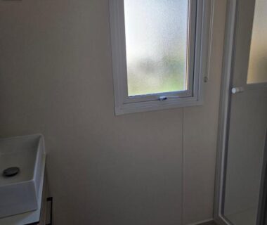 Salle de bain avec lavabo fenêtre et cabine de douche dans le FMLODGE mobil home soleil et sieste