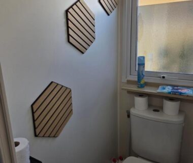WC avec décorations murales hexagonales et fenêtre dans le FMLODGE mobil home soleil et sieste