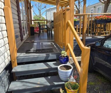 Terrasse en bois avec marches et pots de fleurs du FMLODGE-mobilhome olivier au sable du midi
