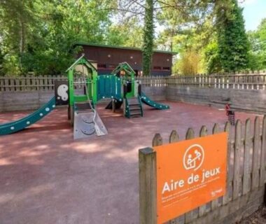 Aire de jeux clôturée avec structure de jeux au camping Famille Peeters