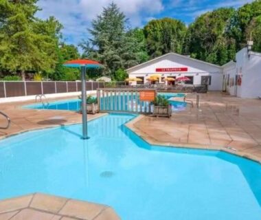 Piscine extérieure et pataugeoire sur terrasse dallée au camping Famille Peeters