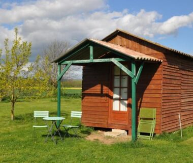 Prairie avec cabane en bois et mobilier de jardin dans la Ferme équestre Les Chevaliers