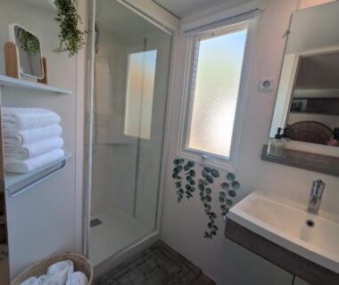Salle de bain avec douche vasque et serviettes au Ferret Family Lodge camping Les Embruns