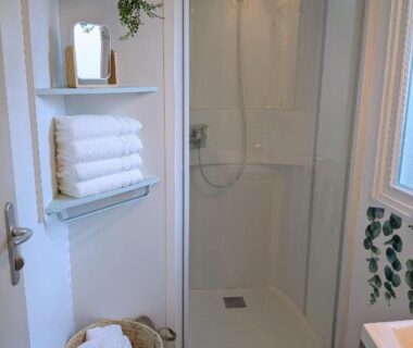 Salle de bain avec douche vitrée et serviettes dans le Ferret Family Lodge camping Les Embruns