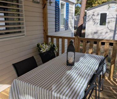 Terrasse couverte avec table et chaises du Ferret Family Lodge camping Les Embruns