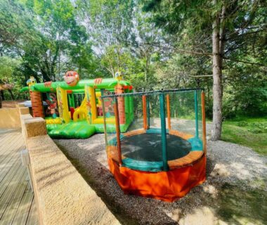 Aire de jeux avec trampoline et structure gonflable au Flower Camping La Pibola