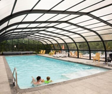 Piscine couverte avec baigneurs sous verrière au Flower Camping La Sténiole
