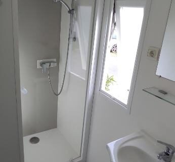 Salle de bain compacte avec douche et lavabo dans la tiny house Franck's Les Viviers