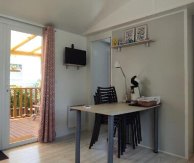 Intérieur avec coin bureau et terrasse en bois dans la tiny house Franck’s Les Viviers