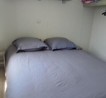 Chambre intérieure avec lit double et étagère dans Franck's tiny house Les Viviers