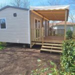 Terrasse en bois devant mobil home dans le camping Frédéric et Maëva
