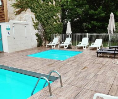 Terrasse avec piscine et transats au camping Frédéric et Maëva