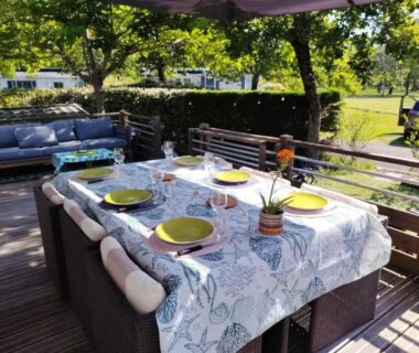 Terrasse avec table dressée et canapés au camping Fun et Nature