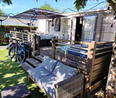 Terrasse ombragée avec canapé et vélos au mobil-home Fun et Nature