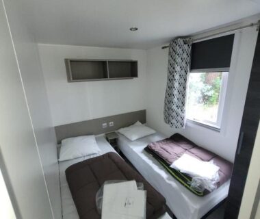 Chambre avec deux lits et serviettes dans le mobilhome GUIG99 camping les dunes de Contis