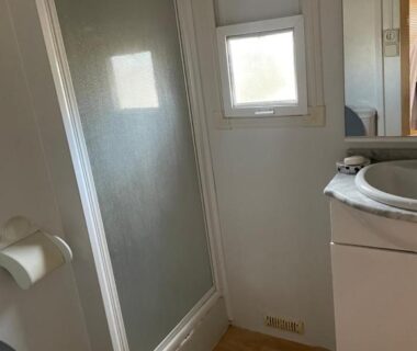 Salle de bain avec cabine de douche et WC dans le camping Gard les Dolmens