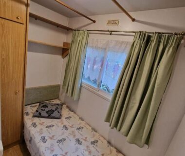 Intérieur chambre avec lit simple et armoire dans le mobil-home Gard les Dolmens