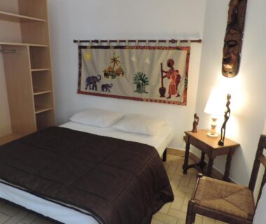 Chambre avec lit double lampe et tenture murale au Gite Le Bois Fleuri