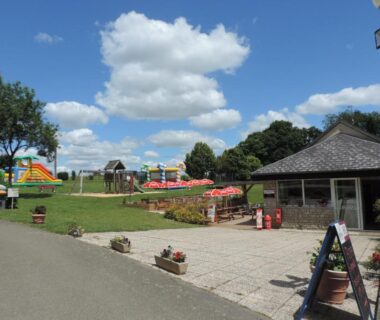 Espace extérieur avec aire de jeux et terrasse au Gite Le Bois Fleuri