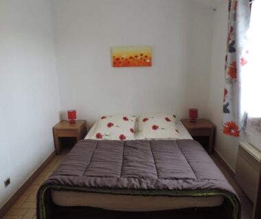Chambre avec lit double et tables de chevet dans le Gite Le Bois Fleuri
