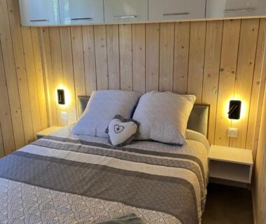 Chambre avec lit double tête de lit en bois et appliques dans le Gîte avec son SPA privatif