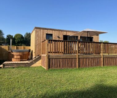 Terrasse extérieure avec spa privatif et chalet en bois du Gîte avec son SPA privatif